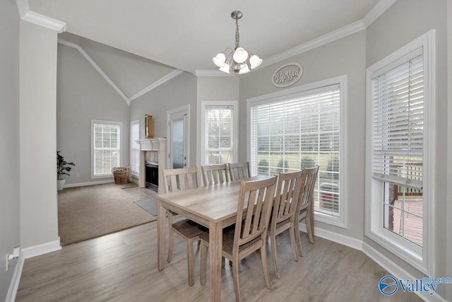 dining space featuring baseboards, a wealth of natural light, ornamental molding, and a chandelier