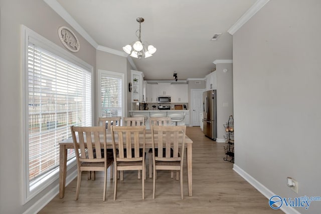 dining space featuring visible vents, ornamental molding, baseboards, and a chandelier