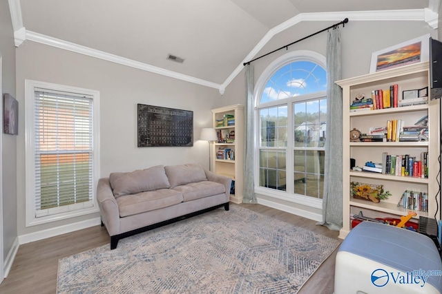 interior space with visible vents, ornamental molding, wood finished floors, and vaulted ceiling