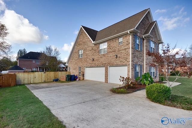 view of home's exterior featuring a lawn, fence, brick siding, concrete driveway, and an attached garage