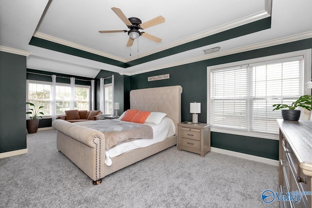 carpeted bedroom featuring baseboards, ornamental molding, a ceiling fan, and a raised ceiling