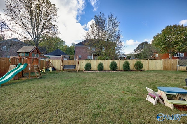 view of yard with a playground, a fenced backyard, and a trampoline