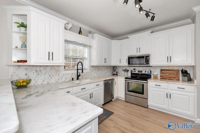 kitchen featuring stainless steel appliances, open shelves, white cabinetry, and a sink