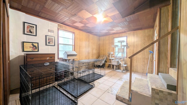 interior space featuring light tile patterned floors, wooden ceiling, and wooden walls