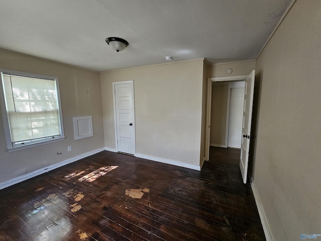 spare room with crown molding, baseboards, and hardwood / wood-style floors