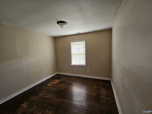 empty room featuring baseboards and hardwood / wood-style flooring