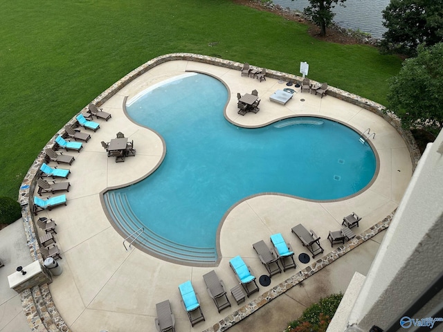 view of swimming pool with a patio and a lawn