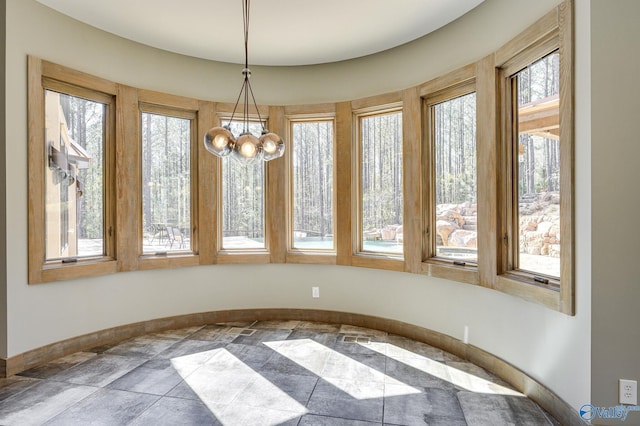 unfurnished dining area with tile patterned floors, a notable chandelier, and plenty of natural light