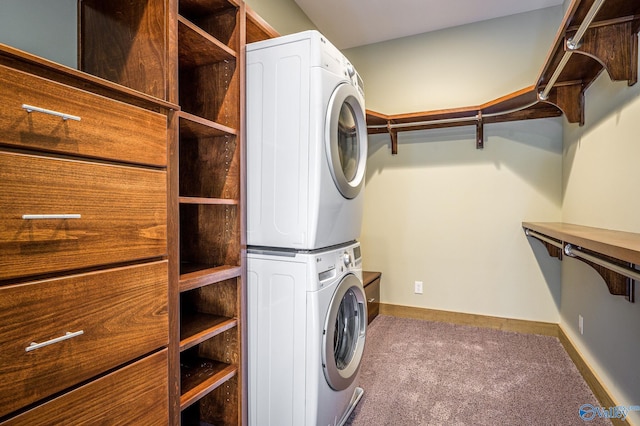 laundry area with laundry area, carpet flooring, stacked washer and clothes dryer, and baseboards