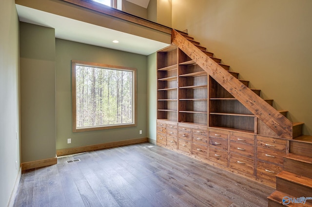 interior space featuring stairs, wood finished floors, visible vents, and baseboards