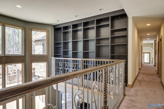 corridor featuring carpet, a healthy amount of sunlight, baseboards, and recessed lighting