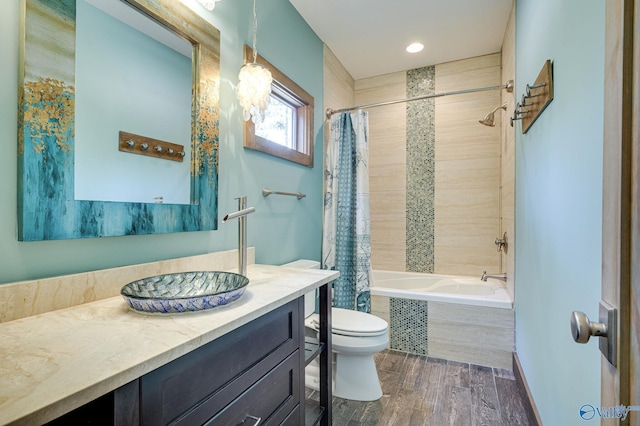 full bathroom featuring tiled shower / bath combo, vanity, toilet, and wood finished floors