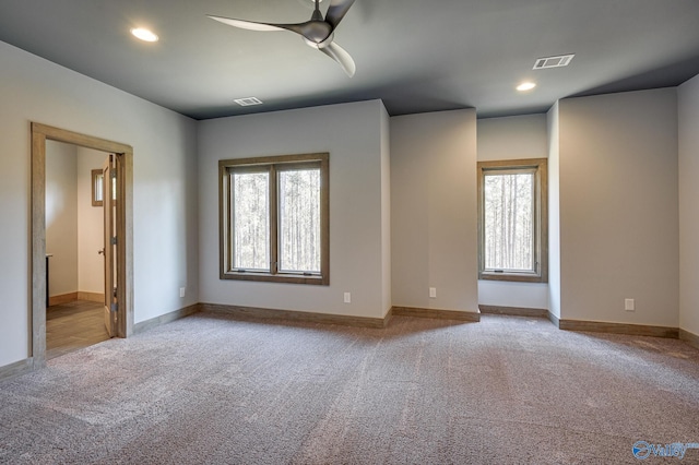 carpeted spare room featuring baseboards, recessed lighting, visible vents, and a healthy amount of sunlight
