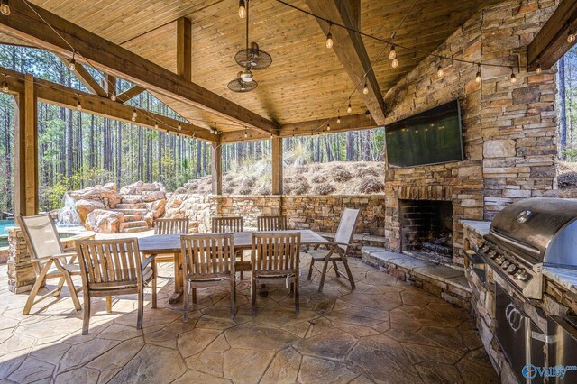 view of patio with area for grilling and an outdoor stone fireplace