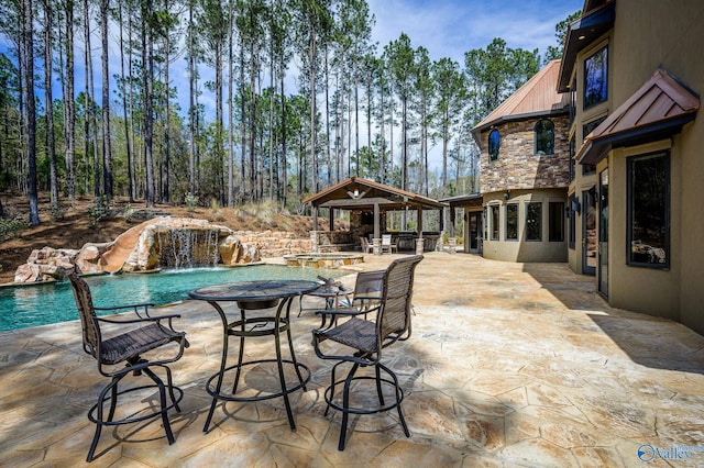 view of swimming pool with an outdoor fire pit, a pool with connected hot tub, a patio area, and a gazebo