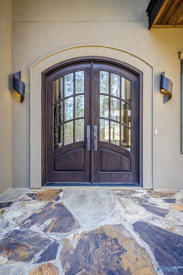 property entrance featuring french doors and stucco siding