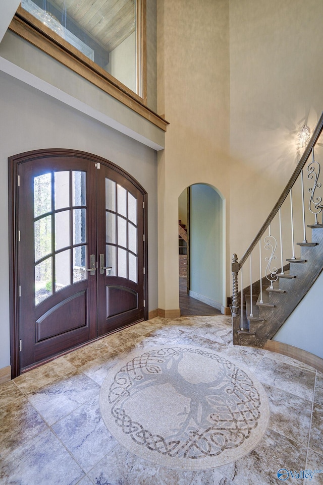 entryway featuring french doors and a towering ceiling