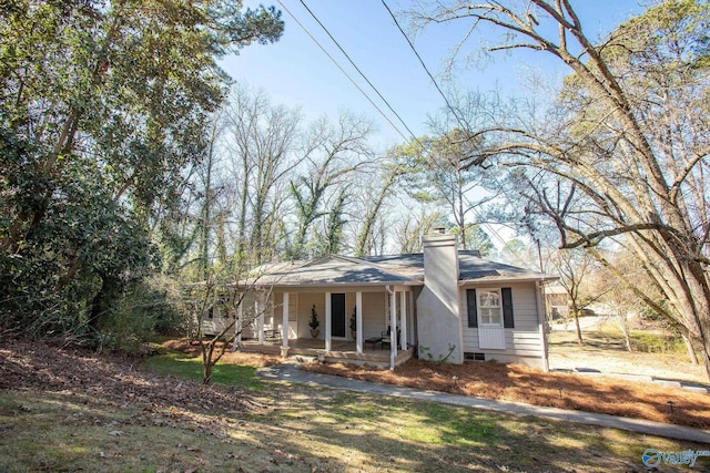 view of front facade featuring covered porch and a chimney