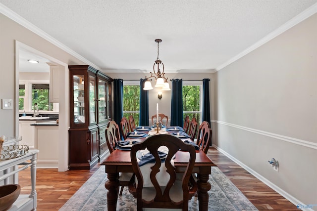 471 Oak Trl NE, Hartselle, AL 35640 - dining space with light wood finished floors, a textured ceiling, crown molding, a chandelier, and baseboards