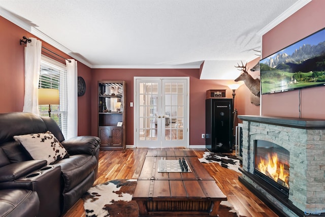 471 Oak Trl NE, Hartselle, AL 35640 - living room with crown molding, wood finished floors, french doors, a stone fireplace, and a textured ceiling
