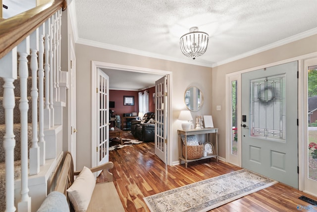 471 Oak Trl NE, Hartselle, AL 35640 - entryway featuring wood finished floors, crown molding, french doors, a textured ceiling, and a chandelier