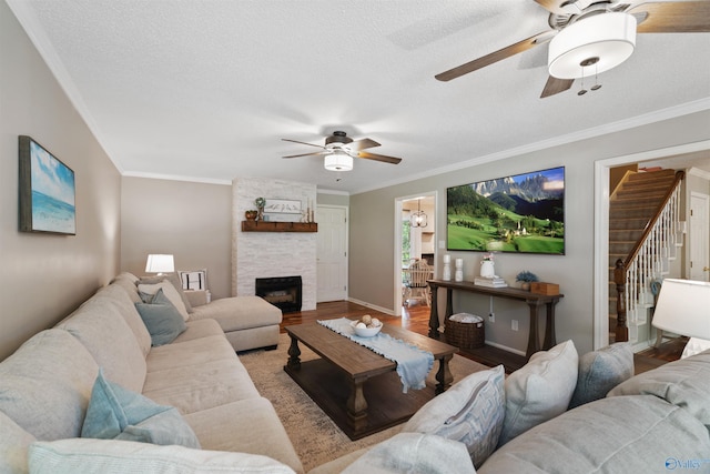 471 Oak Trl NE, Hartselle, AL 35640 - living area featuring a ceiling fan, wood finished floors, crown molding, stairway, and a fireplace