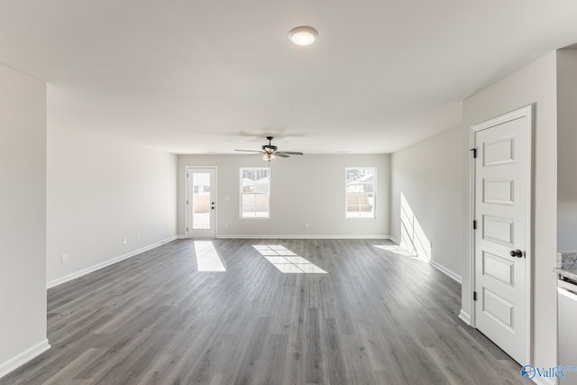 unfurnished living room featuring wood finished floors, a ceiling fan, and baseboards