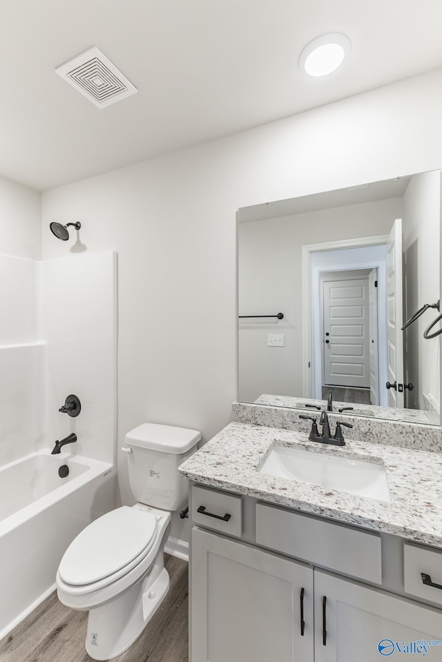 full bathroom featuring hardwood / wood-style floors, shower / tub combination, vanity, and toilet