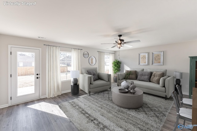 living room featuring wood-type flooring and ceiling fan