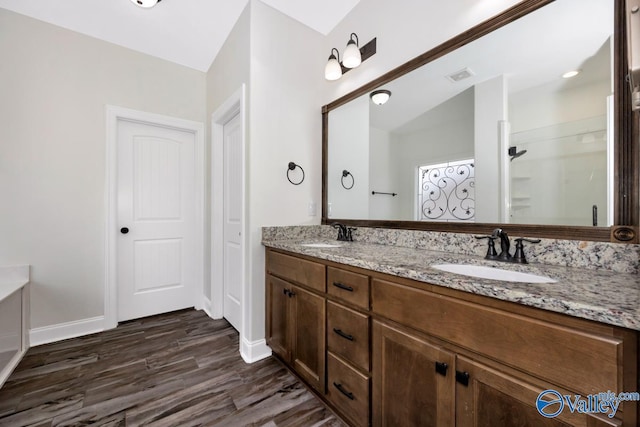 bathroom with hardwood / wood-style flooring, vanity, and walk in shower