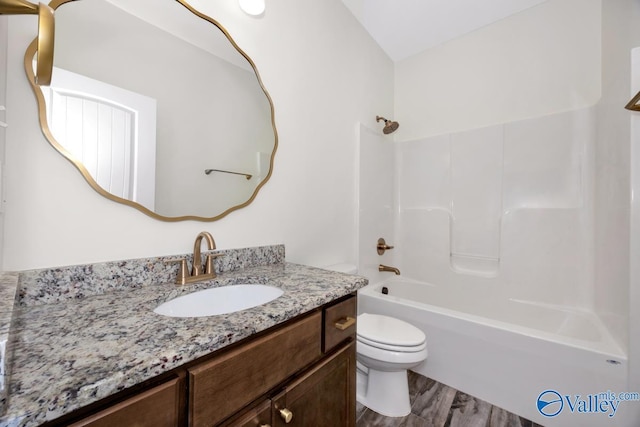 full bathroom featuring vanity, hardwood / wood-style flooring, bathing tub / shower combination, and toilet