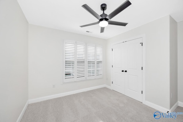 unfurnished bedroom with light carpet, a closet, and ceiling fan