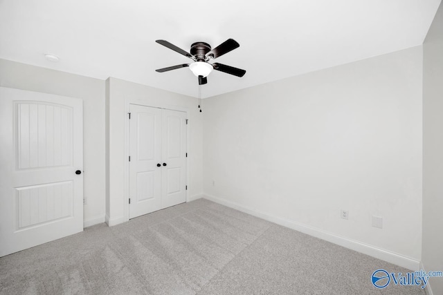 unfurnished bedroom featuring ceiling fan, a closet, and light carpet