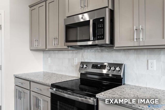 2000 Austin Dr NE, Cullman, AL 35058 - kitchen featuring light stone counters, decorative backsplash, gray cabinets, and stainless steel appliances