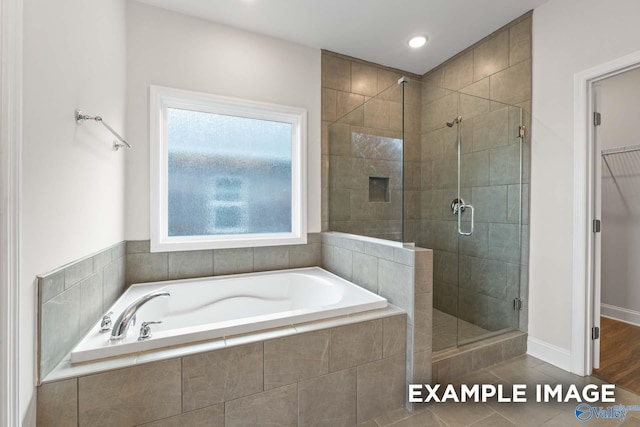 2000 Austin Dr NE, Cullman, AL 35058 - full bathroom featuring tile patterned floors, a garden tub, a shower stall, baseboards, and a spacious closet