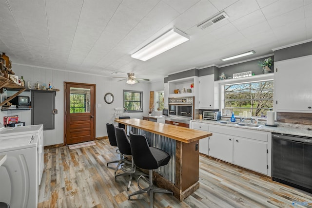 kitchen with sink, light hardwood / wood-style flooring, a kitchen breakfast bar, black dishwasher, and white cabinets