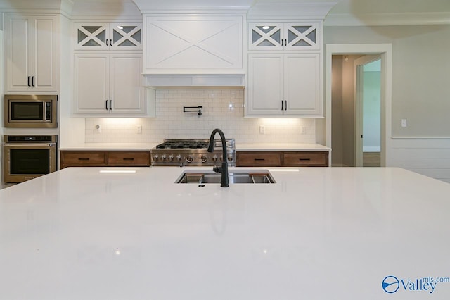 kitchen featuring white cabinetry, appliances with stainless steel finishes, light countertops, and a sink