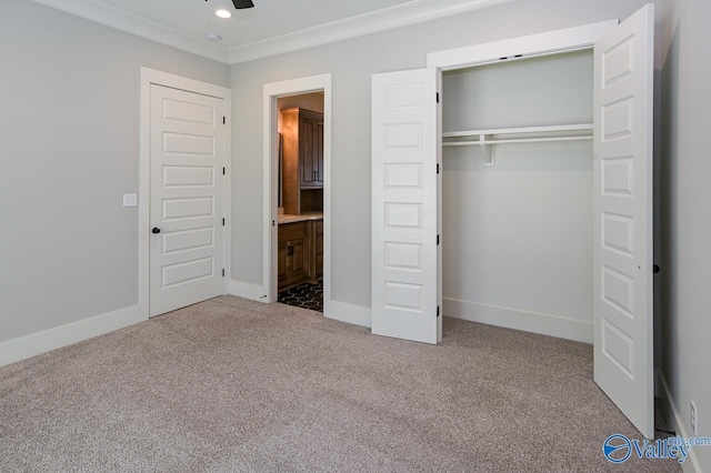 unfurnished bedroom with ornamental molding, a closet, carpet flooring, and baseboards