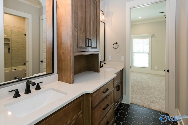 bathroom with double vanity, shower / washtub combination, a sink, and crown molding