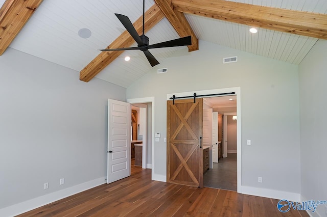 unfurnished bedroom featuring a barn door, visible vents, baseboards, beam ceiling, and dark wood finished floors