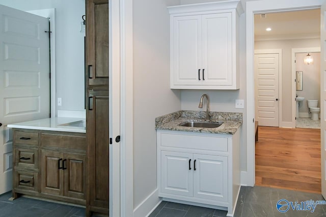 bar with dark wood-style floors, recessed lighting, a sink, and baseboards