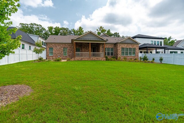 rear view of house featuring a lawn