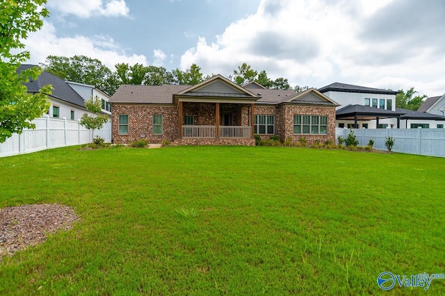 view of front of home featuring a fenced backyard, brick siding, and a front lawn