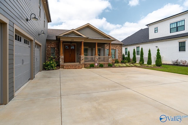 craftsman house with a porch, concrete driveway, and brick siding