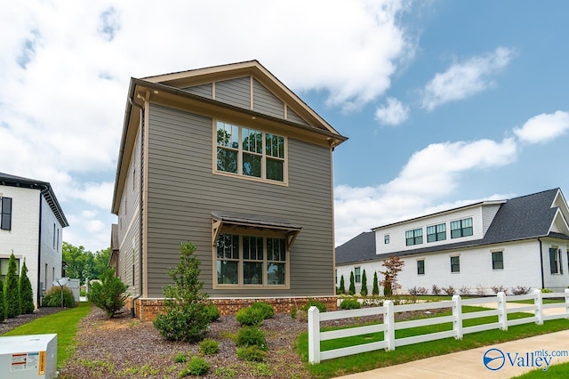 view of front of property featuring brick siding and fence