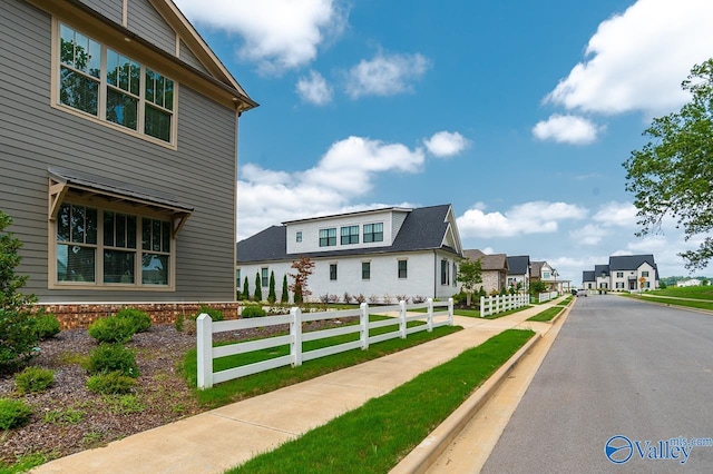 view of property exterior featuring a fenced front yard and a residential view