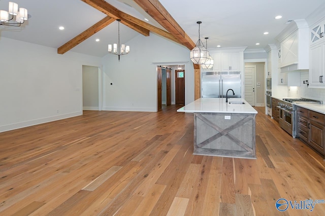 kitchen featuring high quality appliances, light wood-type flooring, a notable chandelier, and white cabinets