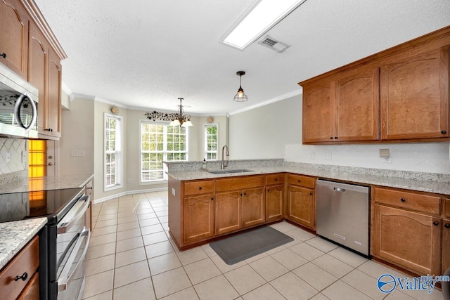kitchen with stainless steel appliances, a peninsula, a sink, visible vents, and crown molding