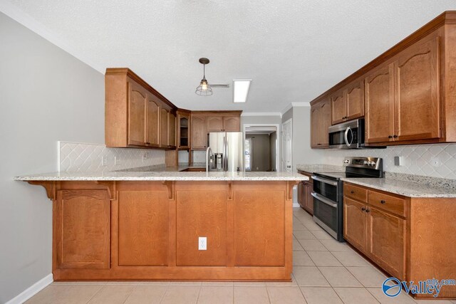 kitchen featuring stainless steel appliances, a peninsula, backsplash, light stone counters, and light tile patterned floors