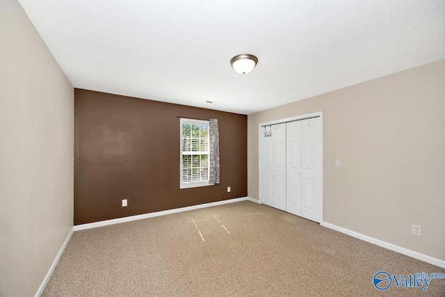 unfurnished bedroom with baseboards, a closet, and carpet